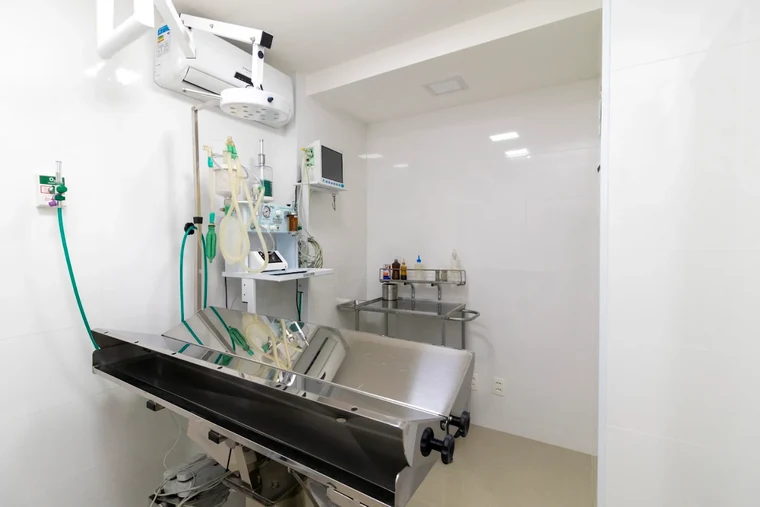 Sala de procedimentos com mesa de inox e equipamento