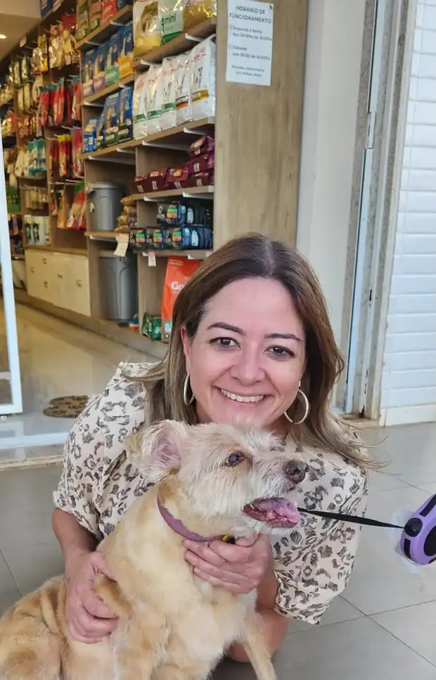 Dra. Mariani com um cão no colo, na loja da Personal Dog